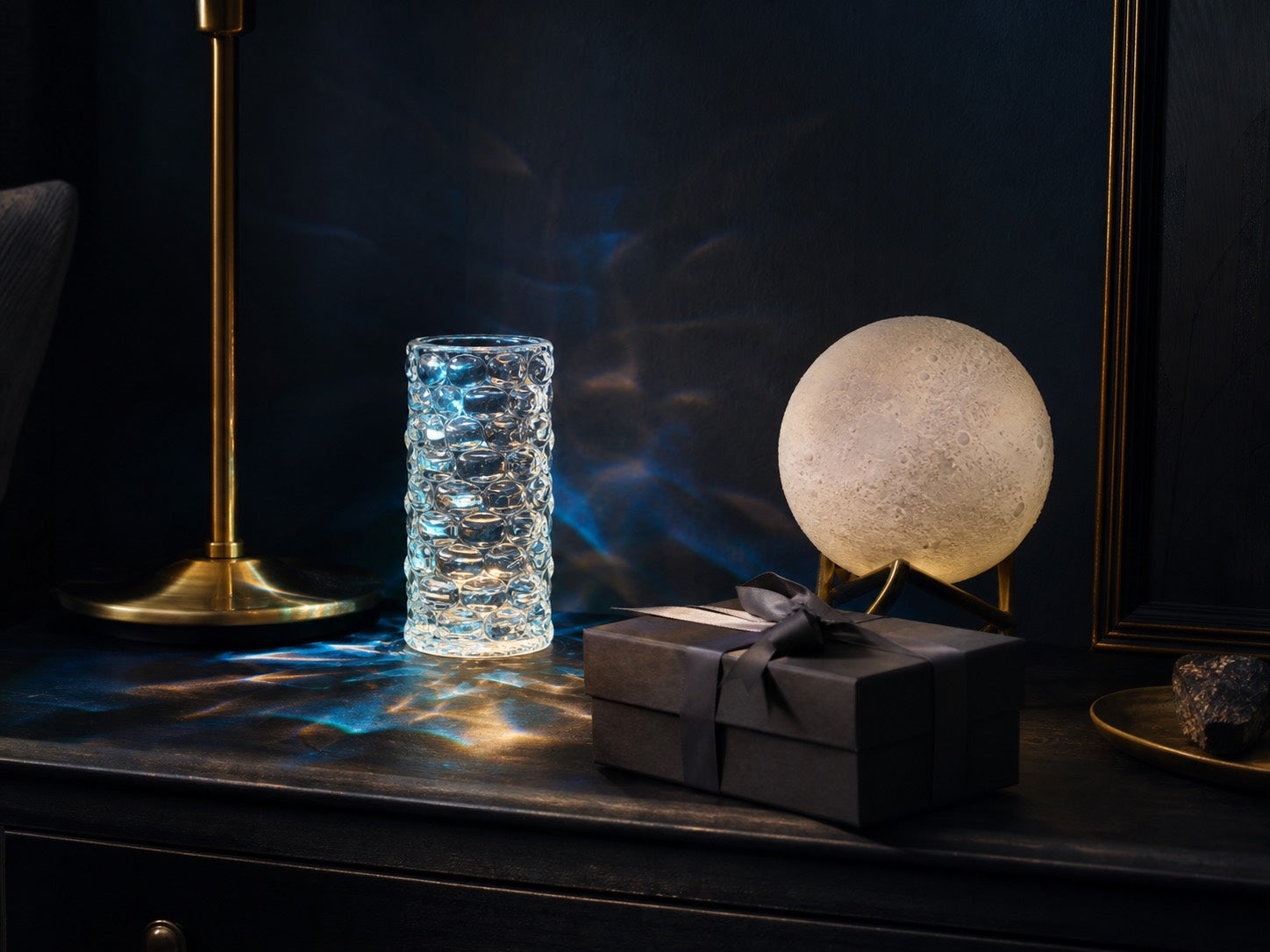 Moody gift scene with crystal mood light, moon lamp, and black gift box